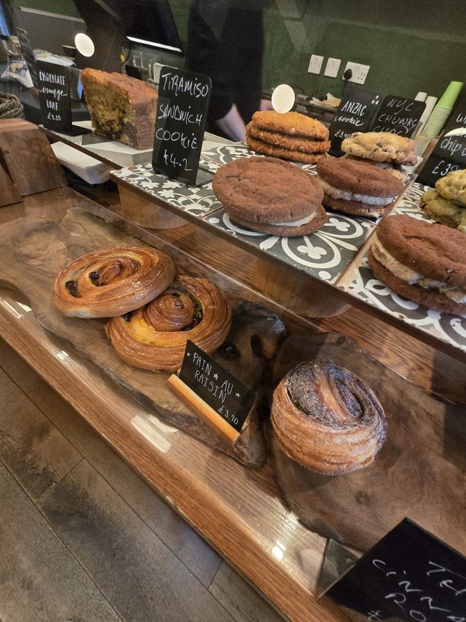 Pastry shelf stacked with cruffins and cakes