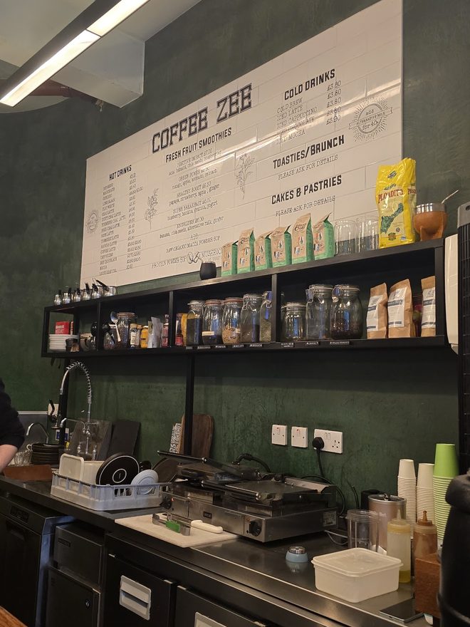 Back bar shelving with syrup bottles and snacks behind the counter