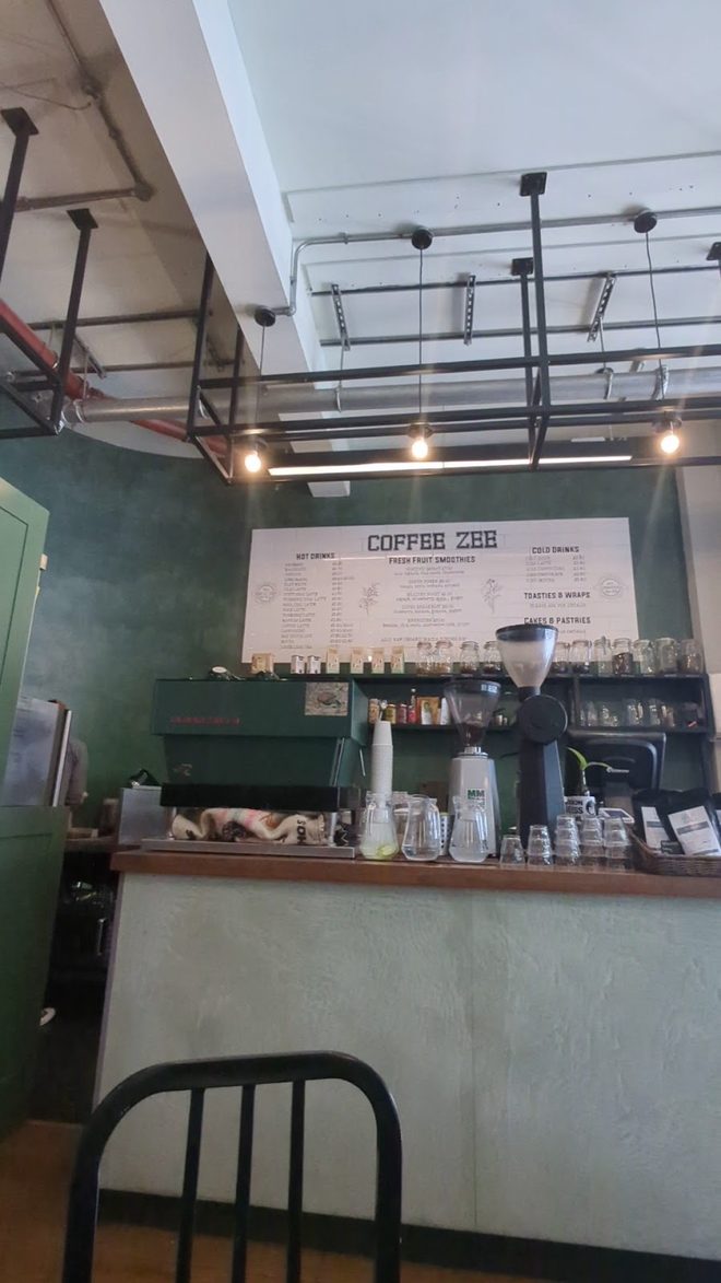 Dark green back wall and counter under industrial ceiling lights