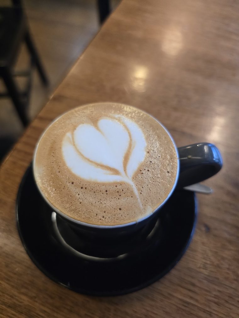 Cappuccino with latte art in a dark blue cup