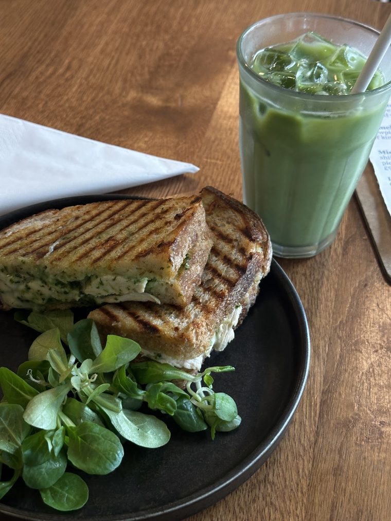 Toasted panini on a black plate with salad leaves